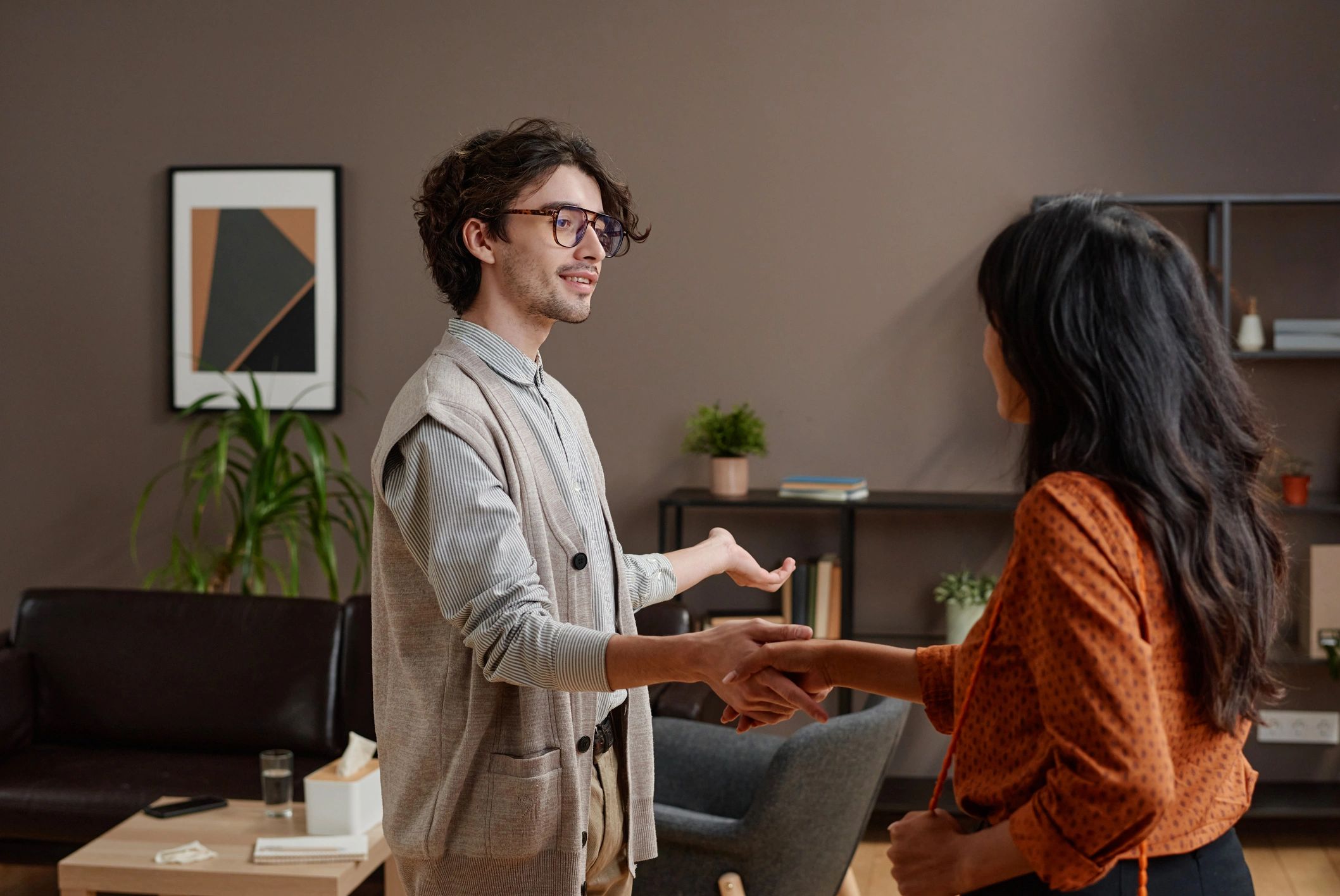 Customer and service professional shaking hands at a counter