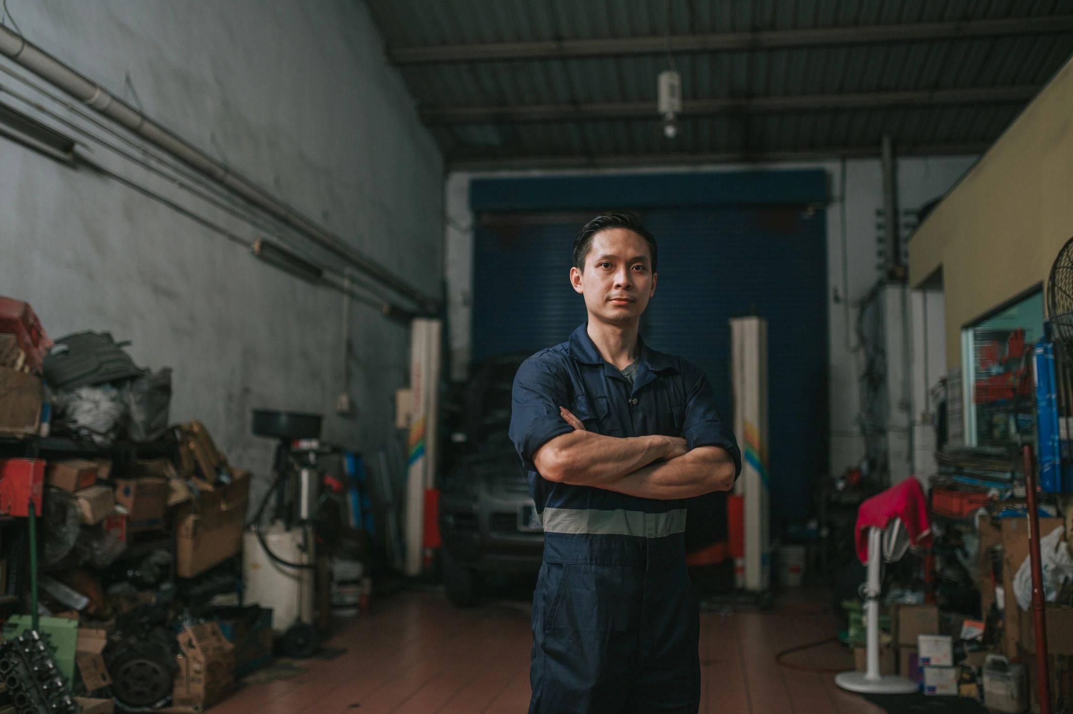 Technician standing in front of an auto repair shop
