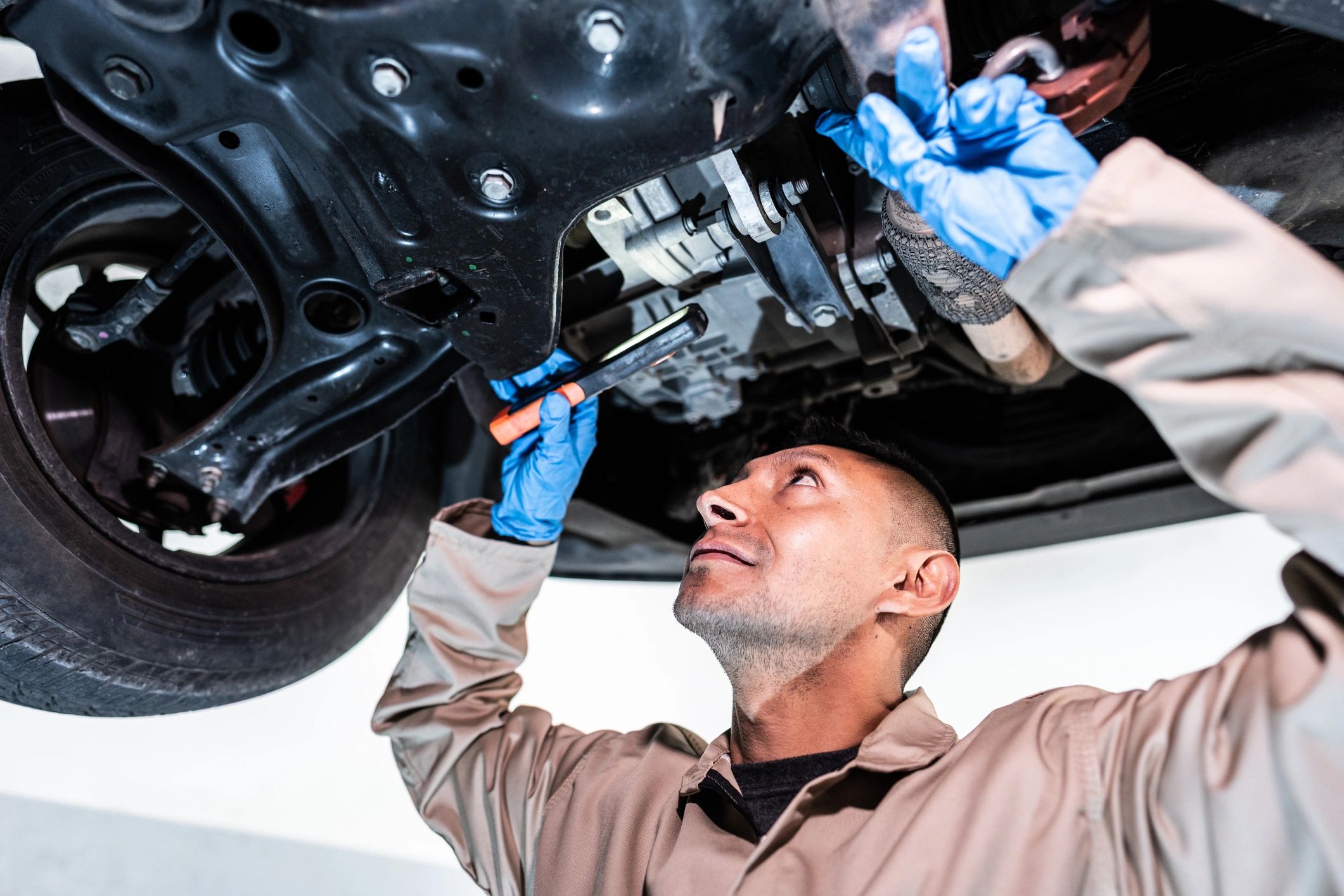 Mechanic inspecting a vehicle in a repair bay