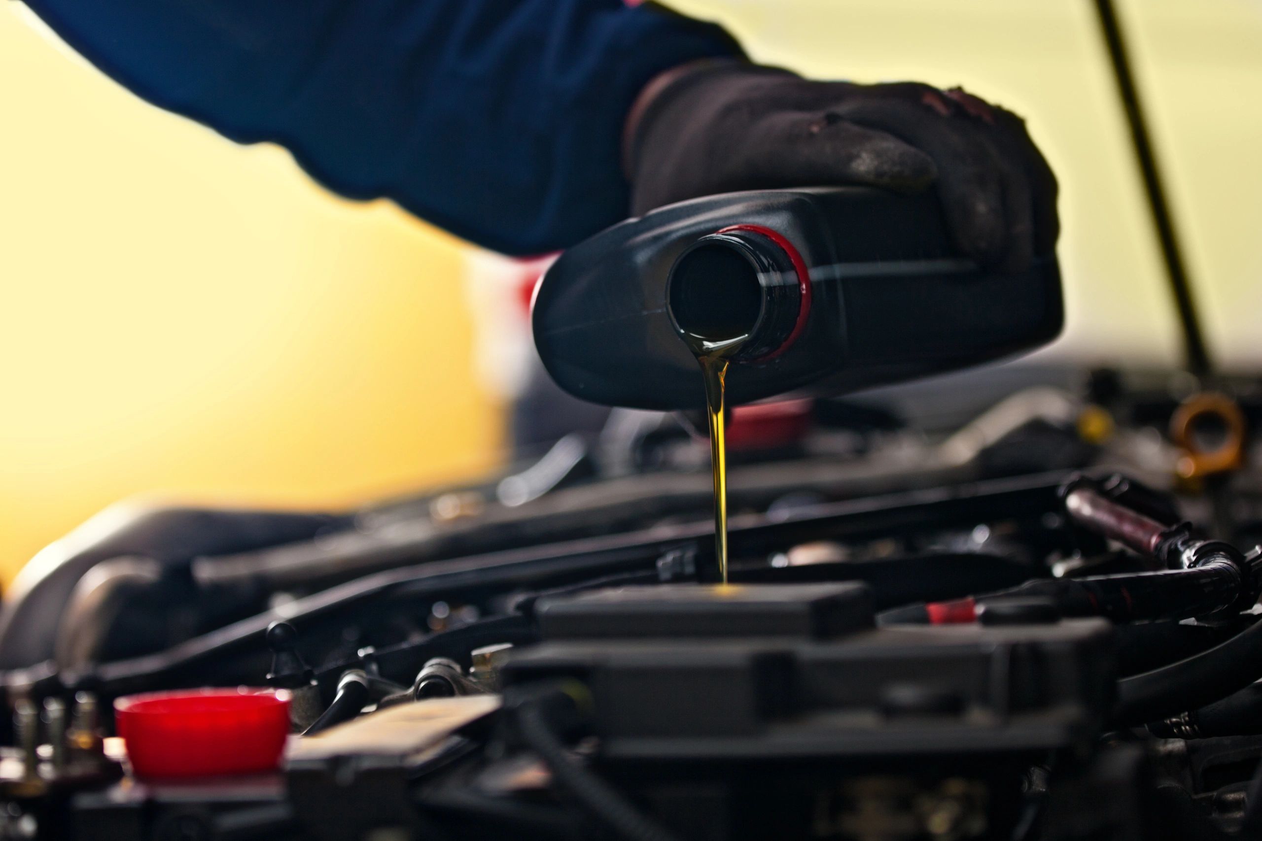 Technician performing a fluid service in a shop
