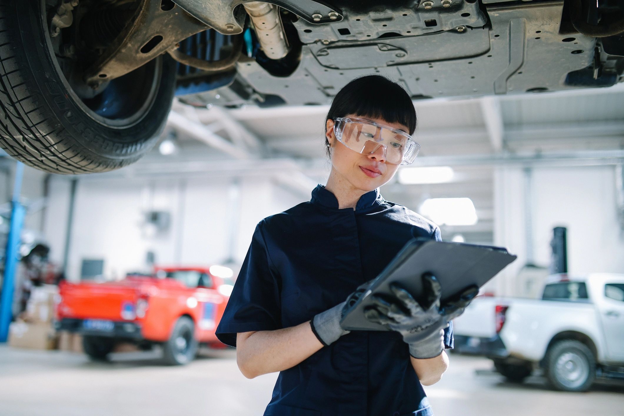 Mechanic using a tablet to run vehicle diagnostics in a repair shop