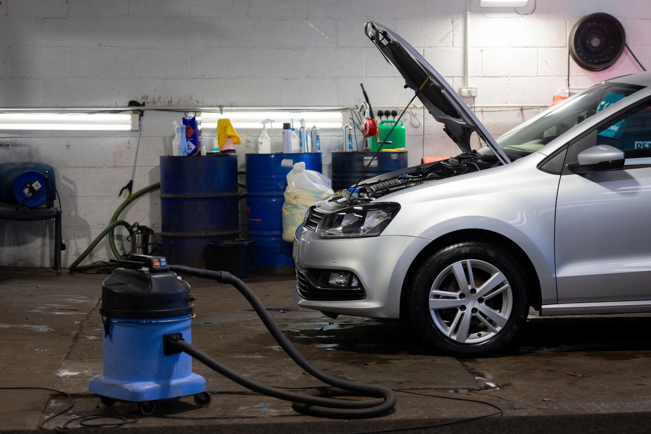 Technician servicing a vehicle in a clean repair bay