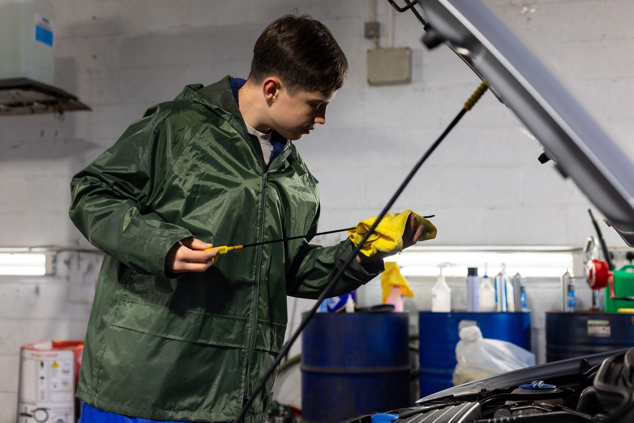 Apprentice checking oil levels during a multi-point inspection